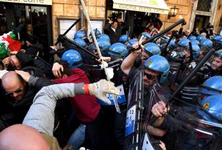 Riot police clash with taxi drivers and street sellers during a demonstration, in Rome, Tuesday, February 21, 2017. A weeklong strike by taxi drivers that has crippled transport in Rome, Milan and Turin is heating up, with cabbies marching through the eternal city to protest legislation they say will favor Uber and other car-hire services.  (Alessandro Di Meo/ANSA via AP)