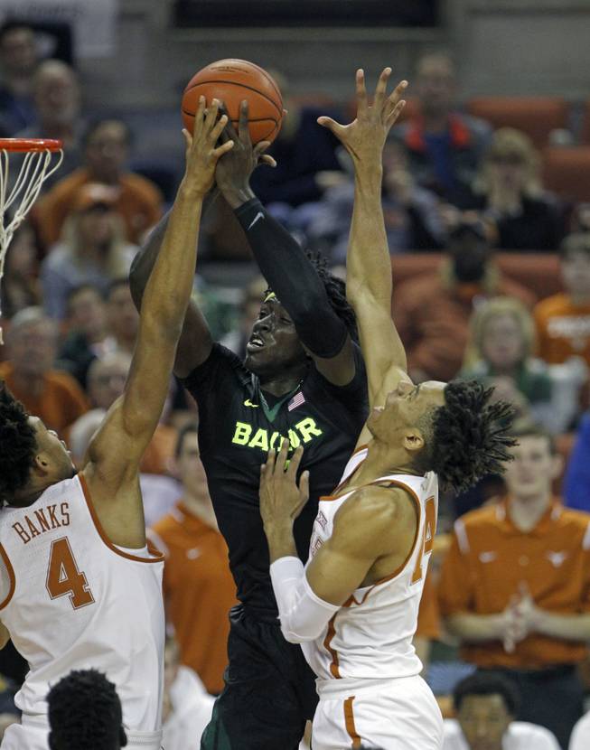 Baylor forward Johnathan Motley, center, shoots against Texas center James Banks, left, and Mareik Isom, right, during the first half of an NCAA college basketball game, Saturday, March 4, 2017, in Austin, Texas.