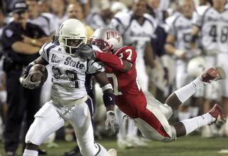 UNLV senior defensive back Jamaal Brimmer (27) grabs the facemask of Utah State junior wide receiver Rod McNeal (23) in second quarter action on Saturday, Sept. 25, 2004 at Sam Boyd Stadium. Brimmer was penalized on the play. SAM MORRIS / LAS VEGAS SUN