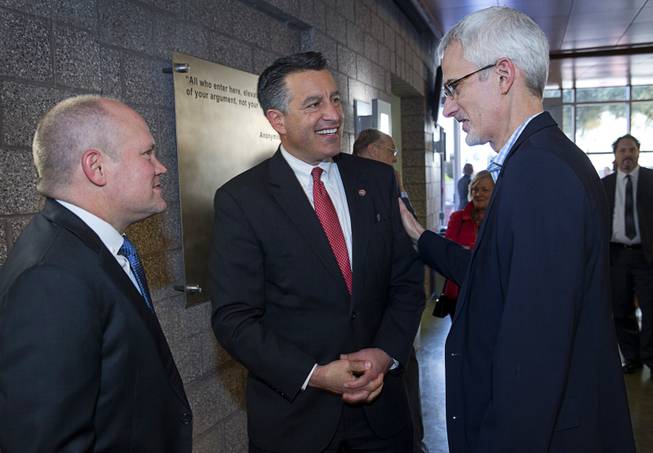 Nevada Governor Brian Sandoval, center, chats with Leif Reid, left and Rory Reid, sons of former Senate Majority Leader Harry Reid (D-Nev) before a ceremony at UNLV Thursday, April 20, 2017.  Harry Reid was officially named as the first Distinguished Fellow in Law and Policy at UNLV's Boyd School of Law.