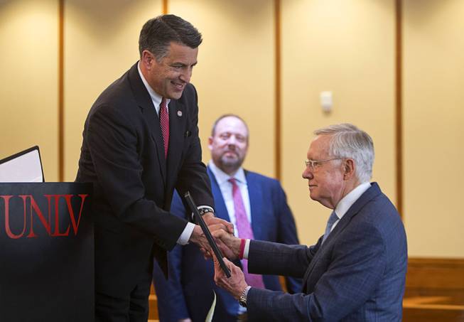 Nevada Gov. Brian Sandoval, left, presents a certificate of recogmition to former Senate Majority Leader Harry Reid (D-Nev) during a ceremony at UNLV Thursday, April 20, 2017. Reid was officially named as the first Distinguished Fellow in Law and Policy at UNLV's Boyd School of Law.