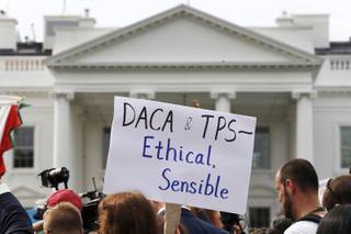 A person holds up a sign in support of the Deferred Action for Childhood Arrivals, known as DACA, and Temporary Protected Status programs during a rally in support of DACA and TPS outside of the White House, in Washington, Tuesday, Sept. 5, 2017. President Donald Trump's administration will 