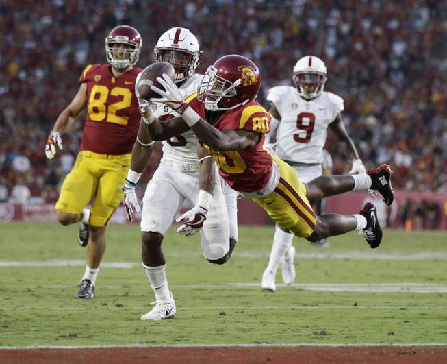 Southern California's Deontay Burnett, center, catches a touchdown pass during the first half of an NCAA college football game against Stanford, Saturday, Sept. 9, 2017, in Los Angeles.