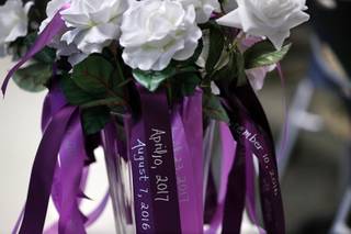 Roses with ribbons that show the names and dates of death of domestic violence victims are displayed during an annual ceremony honoring the lives of domestic violence victims at Metro Police headquarters Wednesday, Sept. 27, 2017. Twenty-one names were added to a domestic violence memorial plaque covering the dates of July 1, 2016 to June 30, 2017.
