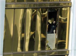 An investigator works in the room at the Mandalay Bay Resort and Casino where a gunman opened fire from on a music festival Tuesday, Oct. 3, 2017, in Las Vegas. The gunman killed dozens and injuring hundreds at the festival. (AP Photo/Marcio Jose Sanchez)
