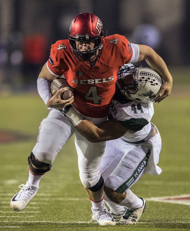 UNLV Rebels quarterback Johnny Stanton (4) looks to the end zone while being wrapped up by Hawaii Warriors linebacker Russell Williams Jr. (44) during their game at Sam Boyd Stadium on Saturday, Nov. 4, 2017.