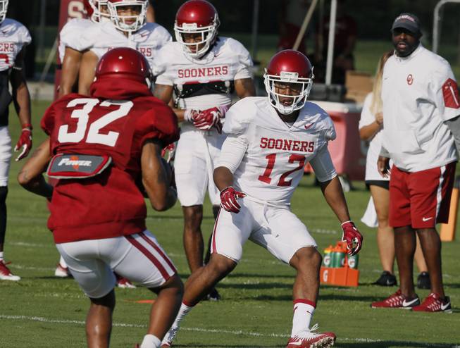 Oklahoma defender Will Johnson (12) moves in on wide receiver Reggie Turner (32) during an NCAA college football practice in Norman, Okla., Thursday, Aug. 17, 2017. 