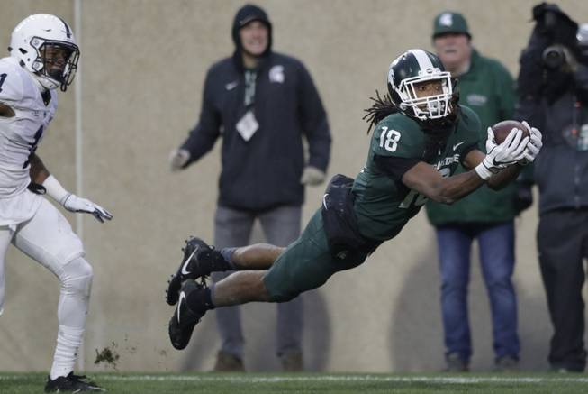 Michigan State wide receiver Felton Davis III (18), defended by Penn State cornerback Christian Campbell (1), catches a 33-yard pass and falls into the end zone for a touchdown during the second half of an NCAA college football game, Saturday, Nov. 4, 2017, in East Lansing, Mich. 