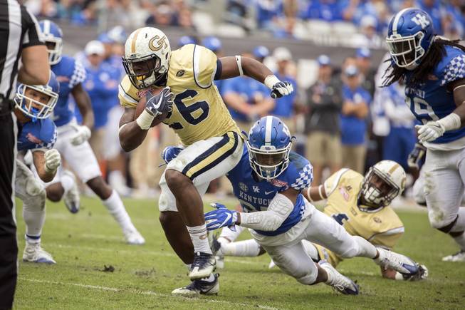 Georgia Tech running back Dedrick Mills (26) is tackled by Kentucky safety Mike Edwards (27) during the second half of the TaxSlayer Bowl NCAA college football game, Saturday, Dec. 31, 2016, in Jacksonville, Fla. Georgia Tech beat Kentucky 33-18. 