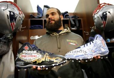 In this Wednesday, Nov. 29, 2017, photo, New England Patriots defensive end Lawrence Guy displays cleats that honor victims of the Oct. 1 Las Vegas shooting, left, and families who have lost an infant, right, in the team’s locker room in Foxborough, Mass. Guy will honor both causes on the field this weekend during the NFL’s My Cause, My Cleats initiative.