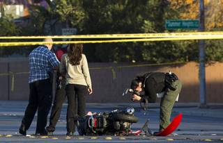 A Metro Police crime scene analyst takes photos as police investigate a fatal accident between a scooter and a Nissan Sentra Tuesday, Dec. 26, 2017.