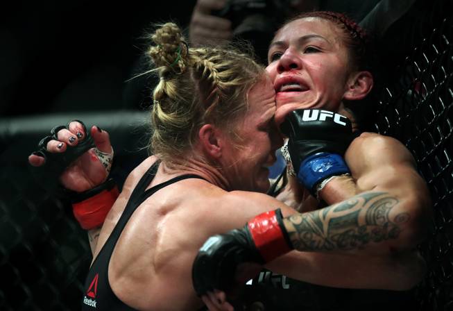 Womens Featherweight Holly Holm drives Cris Cyborg into the cage during their UFC219 fight at the T-Mobile Arena on Saturday, Dec. 30, 2017.