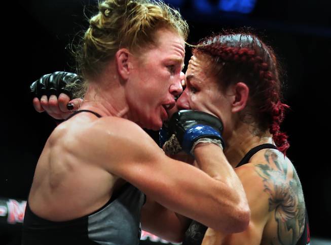 Womens Featherweight Holly Holm connects with a punch to the face of Cris Cyborg into the cage during their UFC219 fight at the T-Mobile Arena on Saturday, Dec. 30, 2017.