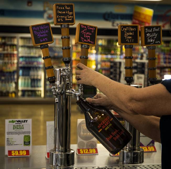 Speedee Mart gas station manager Vickie Snyder pours a growler from the tap, an impressive selection of local and regional beers can be purchased at 5 of the area's shops on Wednesday, Jan. 3, 2018.