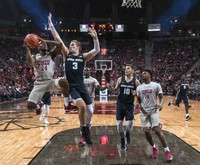 UNLV Rebels guard Jordan Johnson (24) elevates to get off a shot under tight defense by Utah State Aggies guard Sam Merrill (3) during their game at the Thomas & Mack Center on Saturday, Jan. 6, 2018.