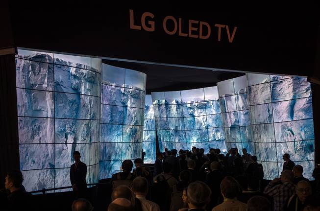 Attendees are amazed as they wander though a display for the LG OLED TV as CES takes over the Las Vegas Convention Center on Tuesday, Jan. 9, 2018.