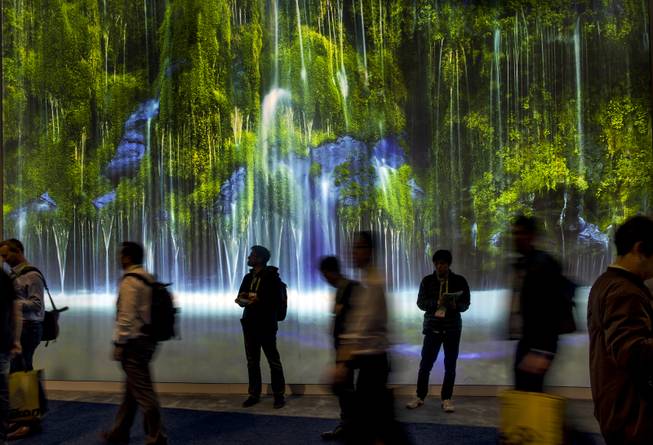 Attendees get lost amongst a giant video waterfall as CES takes over the Las Vegas Convention Center on Tuesday, Jan. 9, 2018.