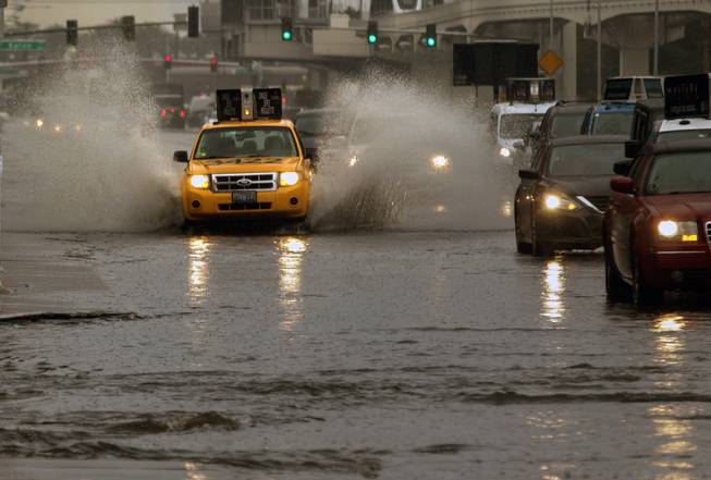 A taxi cab splashes up plenty of water along S. Paradise Road as rain soaks the Las Vegas valley on Tuesday, Jan. 9, 2018.