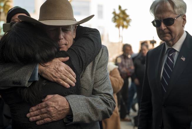 Cliven Bundy receives a hug as attorney Larry Layman stands by following a press conference in front of Metro Police Headquarters on Wednesday, Jan. 10, 2018.