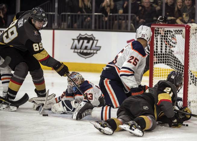 Vegas Golden Knights right wing Alex Tuch (89) is unable to score close in with Edmonton Oilers goaltender Cam Talbot (33) down after players pile up at the net during their game at the T-Mobile Arena on Saturday, Jan. 13, 2018.