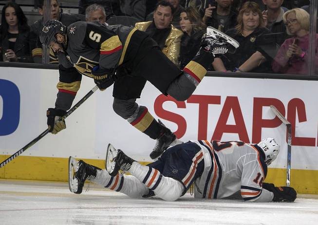 Vegas Golden Knights defenseman Deryk Engelland (5) is upended with a sliding tackle by Edmonton Oilers left wing Jujhar Khaira (16) during their game at the T-Mobile Arena on Saturday, Jan. 13, 2018.