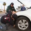 Volunteers Wayne Eady center, and Nicholas Marquart, above, work on Brian Harris' car during a free brake light repair clinic hosted by the Las Vegas Democratic Socialists of America at the First African Methodist Episcopal Church in North Las Vegas, Nev., on Saturday, Jan. 6, 2018.