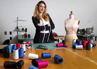 Ermelinda Manos, owner of Behind the Seams, a uniform and apparel design company, poses in a production room at the company Thursday, Jan. 18, 2018.