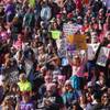 Attendees hold up signs at the Women's March: Power to the Polls at Sam Boyd Stadium, Sunday, Jan. 21, 2018.