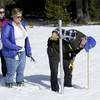 In this Feb. 1, 2018, photo, Frank Gehrke, right, chief of the California Cooperative Snow Surveys Program, for the Department of Water Resources, checks the snowpack depth as Courtney Obergfell, left, and Michelle Mead, center, both of the National Weather Service, look on during the second snow survey of the season near Echo Summit, Calif.