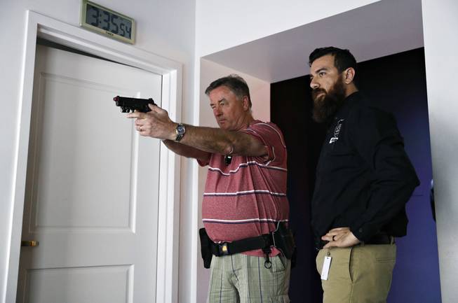 In this April 12, 2018, photo, training officer Albert Dauto, right, instructs Tom Coull at the Use of Force Training Experience in the Mob Museum in Las Vegas. For years the museum has showcased the area's storied past in organized crime, but visitors can now also enjoy a speakeasy, a use of deadly force training experience, and an interactive crime lab exhibit. 