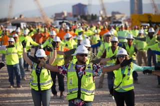 Workers perform bend and stretch exercises before the start of the workday at the Las Vegas Raiders stadium construction site Friday, May 11, 2018. Friday marked the final day of 