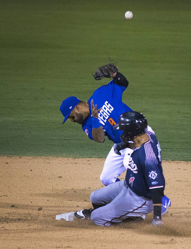 Reno Aces' Kristopher Negron (11) slides in safe at second as Las Vegas 51s' Christian Colon (9) misses the throw at Cashman Field Thursday, June 21, 2018. The 51s beat the Aces 5-3.