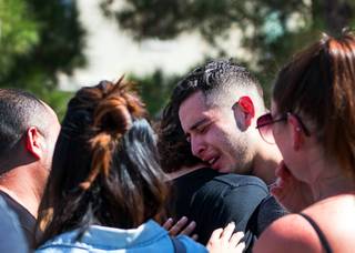 A mourner is consoled as he cries at the Liberty At Paradise Community in Henderson Saturday Sept. 22. He and others were there for a ceremony honoring Selina Rowsell, her son, Arias, and his younger brother, Avi. The three were slain Sept. 20 in the same community by a perpetrator who then took his life