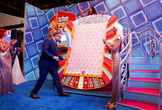Isidra Randal, a Venetian guest services representative, celebrates as she wins a Plinko game with Drew Carey, host of 
