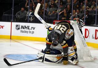 Vegas Golden Knights left wing William Carrier (28) winds up on top of Buffalo Sabres goaltender Carter Hutton (40) after taking a shot on goal in the third period at T-Mobile Arena Tuesday, Oct. 16, 2018.