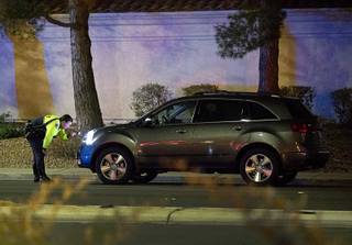A Henderson Police officer looks over the front of a small SUV after a fatal auto-pedestrian accident on Wigwam Parkway near Green Valley Parkway in Henderson Thursday, Dec. 20, 2018.