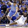 Duke's Zion Williamson (1) falls to the floor with an injury while chasing the ball with North Carolina's Luke Maye (32) during the first half of an NCAA college basketball game in Durham, N.C., Wednesday, Feb. 20, 2019. 