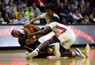 Clark High School's Antwon Jackson (23) fights for the ball with Bishop Gorman players Zaon Collins (10), top, and William McClendon (1) during the Class 4A state high school basketball championship at the Orleans Arena Friday, March 1, 2019.