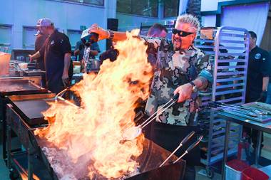 Guy Fieri pours tequila on a charcoal fire during the Grand Tasting at the 13th annual Vegas Uncork’d by Bon Appetit Friday, May 10, 2019, at Caesars Palace in Las Vegas.