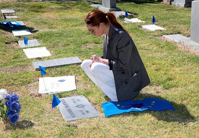Colleen Craig pauses to honor those receiving headstones at Woodlawn Cemetery, where 64 Jews in previously unmarked graves were remembered in a ceremony Sunday, Oct. 6, 2019. 
