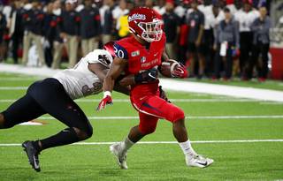 UNLV linebacker Jacoby Windmon tries to tackle Fresno State running back Ronnie Rivers, who scores a touchdown during the first half of an NCAA college football game in Fresno, Calif., Friday, Oct. 18, 2019. 