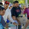 People gather items during a free food distribution for migrant workers evacuated because of the Kincade Fire Thursday, Oct. 31, 2019, in Healdsburg, Calif. 