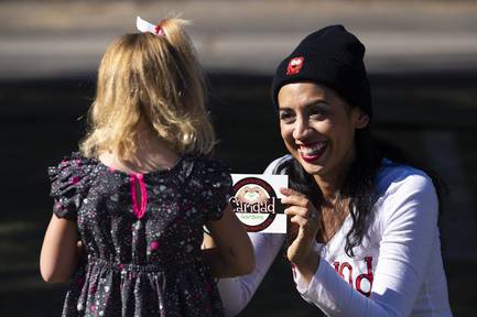Caridad founder Meredith Spriggs gives Hennley Marting, 6, a sticker during the opening ceremony for the Caridad Gardens at Bunkhouse Saloon in downtown Las Vegas, Monday, Nov. 11, 2019.