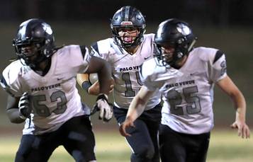 Palo Verde quarterback Paul Myro, center, carries the ball behind Nas Worthy (53) and Dacen Phister (25) during a Mountain Regional quarterfinal game against Las Vegas at Las Vegas High School Friday, Nov. 15, 2019.
