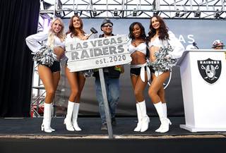 Construction inspector Ben Shirley poses with Las Vegas Raiderettes during a news conference, officially renaming the Oakland Raiders to the Las Vegas Raiders, in front of Allegiant Stadium in Las Vegas Wednesday, Jan. 22, 2020.