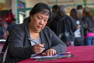 Arlene Lu-Perez fills out a ballot at the Chinatown Mall on the first day of early voting for the Nevada 2020 caucus Saturday, Feb. 15, 2020.