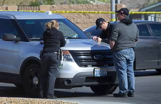 A crime scene analyst and Metro Police investigators confer near the scene of an apparent double murder and suicide in a residential area near Lamb Boulevard and Alexander Road Saturday, March 28, 2020. A man killed his two teenage sons before killing himself on Friday night, according to reports.