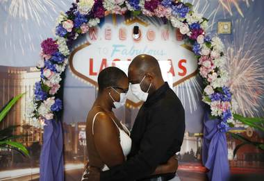 Vaughan Chambers and Alicia Funk put the face coverings on shortly after they exchanged vows and kissed in front of a neon-lit sign in a Las Vegas wedding chapel and posed for photos with an Elvis impersonator who officiated at their wedding.