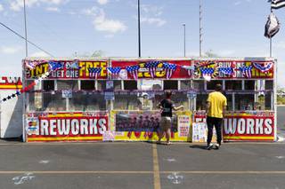 Yessenia Lester, left, helps a customer pick out products at a TNT fireworks booth, Monday, June 29, 2020.