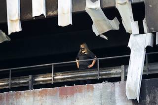 A Four Queens employee looks out from the parking garage after an early morning fire at the garage at Casino Center Boulevard and Carson Avenue in downtown Las Vegas Thursday, Sept. 17, 2020. At least five cars on the first level of the garage burned, officials said.